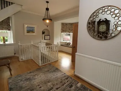 a living room with a clock on the wall at North Lodge in Annan