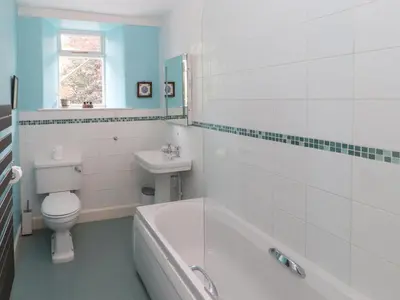 a bathroom with a tub and a toilet and a sink at 1 Field Foot Cottage in Ambleside