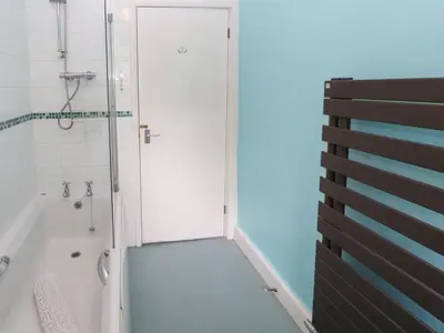 a bathroom with a shower and a toilet and a tub at 1 Field Foot Cottage in Ambleside