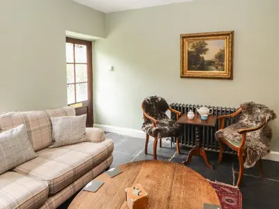 a living room with a couch and chairs and a table at 1 Field Foot Cottage in Ambleside
