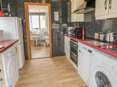 a kitchen with a stove and a counter top at Wagtail Cottage in Mainsriddle