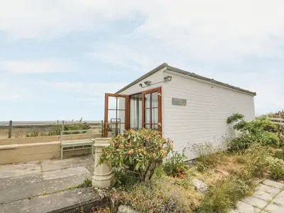 a small white building with windows on the side at Wagtail Cottage in Mainsriddle
