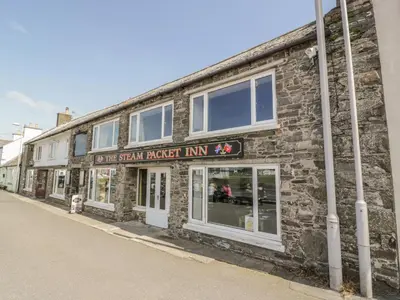 a brick building with a sign that reads the sixth fastest inn at The Moorings in Isle of Whithorn