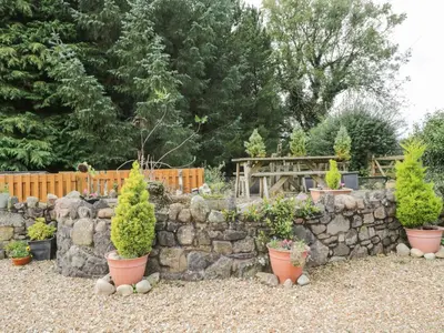 a stone retaining wall with potted plants on it at The Cottage at Graysondale Farm in Cockermouth