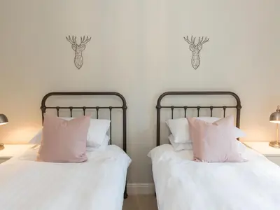 two beds with pink pillows sitting next to each other at Stag Cottage in Penrith