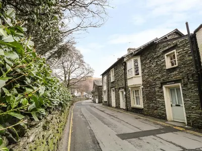 an old stone house on a cobblestone street at Rowan Cottage in Grasmere