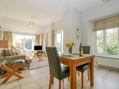 a living room with a table and a couch at Garden Cottage in Keswick
