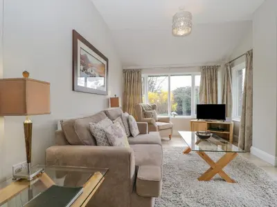 a living room with a couch and a table at Garden Cottage in Keswick