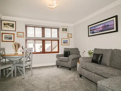 a living room with a couch and a table and chairs at Andra Ghyll in Keswick