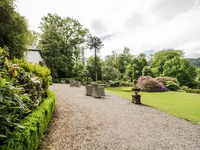 a walkway in a park with chairs and flowers at Thirlmere Suite in Thirlmere