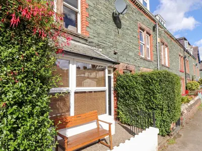 a wooden bench sitting in front of a building at Archers in Keswick