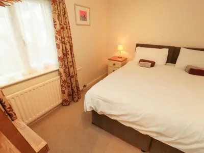 a bedroom with a large bed and a window at Archers in Keswick