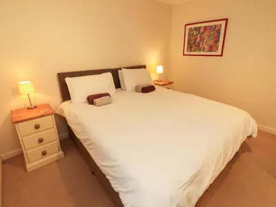 a bedroom with a large white bed with two lamps at Archers in Keswick