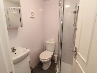 a white bathroom with a toilet and a shower at Archers in Keswick