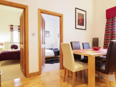 a dining room with a table and a bedroom at Keswick Loft in Keswick