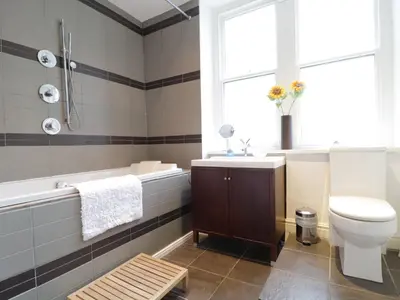a bathroom with a sink toilet and a window at Keswick Loft in Keswick