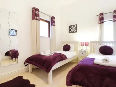 a bedroom with two beds and a mirror at Keswick Loft in Keswick