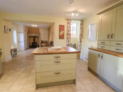a kitchen with white cabinets and a wooden counter top at Greta Mill in Keswick