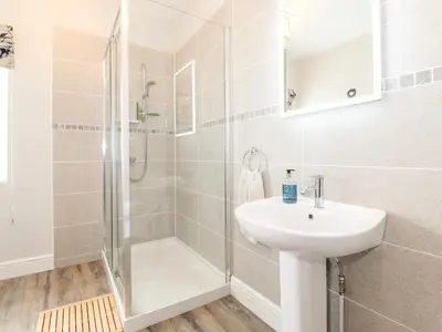 a white bathroom with a sink and a shower at How End in Braithwaite