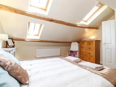 a bedroom with a large white bed with skylights at How End in Braithwaite