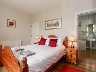 a bedroom with a large bed with red pillows at How End in Braithwaite