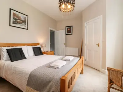 a bedroom with a large bed and a chandelier at How End in Braithwaite