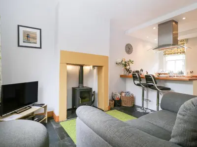 a living room with a couch and a stove at Banks Place in Keswick