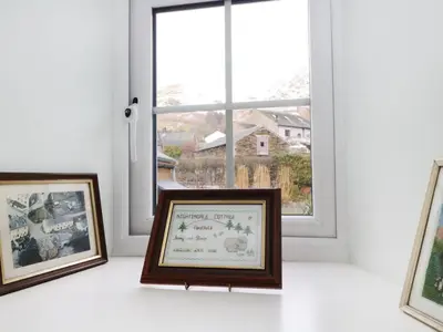 three framed photographs sitting on a window sill in front of a window at Nightingale Cottage in Threlkeld