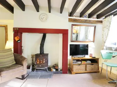 a living room with a fireplace and a tv at Nightingale Cottage in Threlkeld