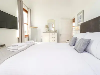 a white bedroom with a large bed with towels on it at Sky View in Keswick