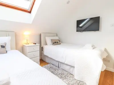 a bedroom with two beds and a tv on the wall at Sky View in Keswick