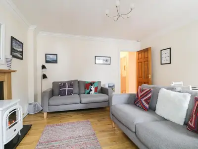 a living room with two couches and a fireplace at Siskin in Keswick
