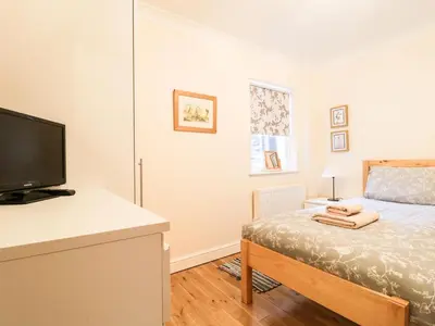 a bedroom with a bed and a flat screen tv at Siskin in Keswick