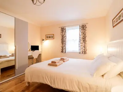 a bedroom with a large white bed and a window at Siskin in Keswick