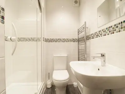 a bathroom with a toilet and a sink and a shower at Fox's Den in Keswick