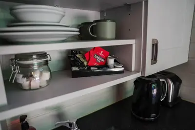 a kitchen cupboard with plates and dishes in it at Reflection in Canonbie