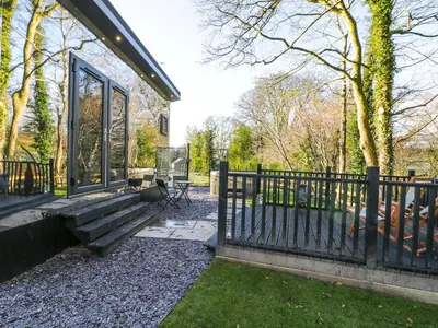 a house with a fence and a bench at Reflection in Canonbie
