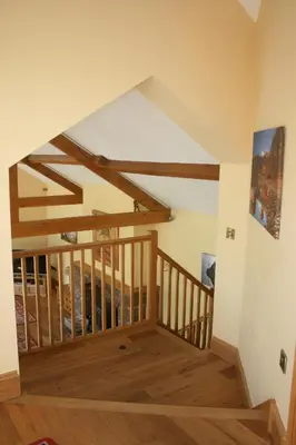 a staircase in a house with wooden beams at The Byre in Keswick