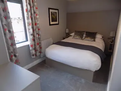 a small bedroom with a bed and a window at The Old Wool House Apartments in Carlisle