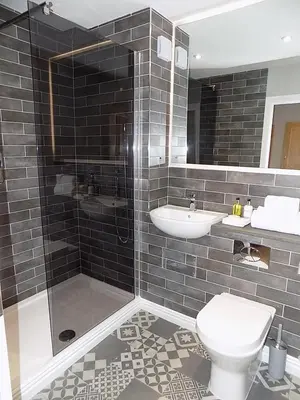 a bathroom with a shower and a toilet and a sink at The Old Wool House Apartments in Carlisle