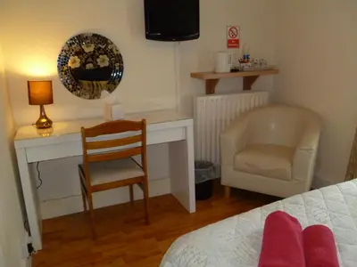 a bedroom with a desk and a chair at Greenlaw Guest House in Gretna Green