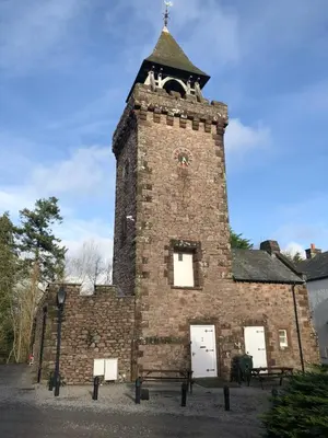 a brick building with a tower with a clock on it at Irton Hall in Eskdale