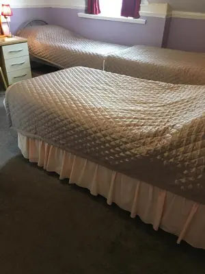 two twin beds in a bedroom with a window at Adelphi Guest House in Douglas