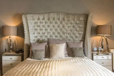 a bedroom with a large white bed with two lamps at Lochside House Hotel & Spa in New Cumnock