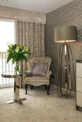 a living room with a chair and a lamp at Lochside House Hotel & Spa in New Cumnock