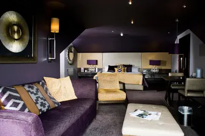 a living room with a purple couch and a bedroom at Lochside House Hotel & Spa in New Cumnock