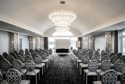a conference room with chairs and a projection screen at Lochside House Hotel & Spa in New Cumnock
