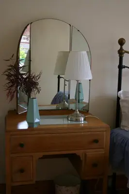 a desk with a mirror and a lamp on it at Garden Cottage in Prestwick
