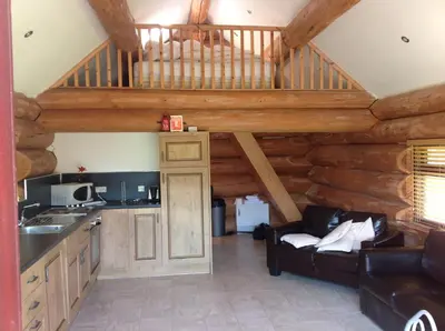 a living room with a kitchen and a staircase in a cabin at lyne view, log cabin in Carlisle