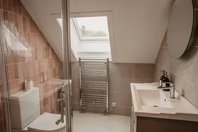 a bathroom with a sink and a toilet and a window at The Murray Arms Hotel in Gatehouse of Fleet